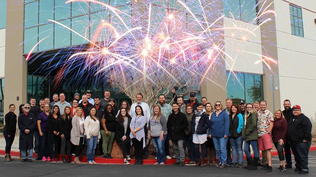 a group of people standing in front of a building with fireworks in the background