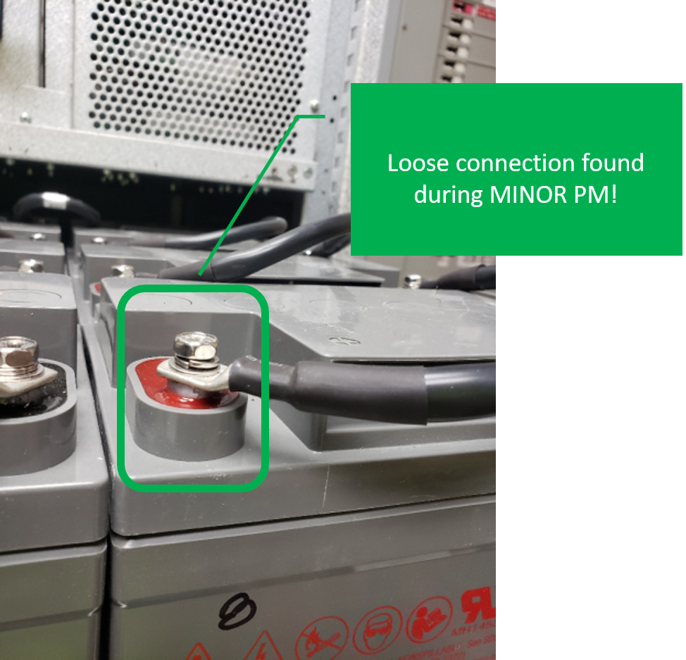 a battery with a green sign displaying a loose connection found during minor preventative maintenance